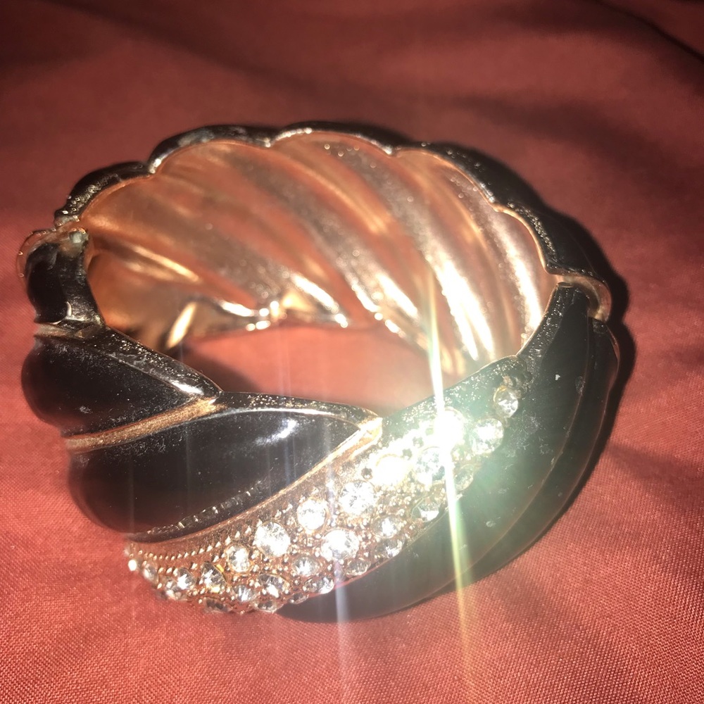 black bracelet.encrusted with imitation diamonds. opens to allow the hand in.
